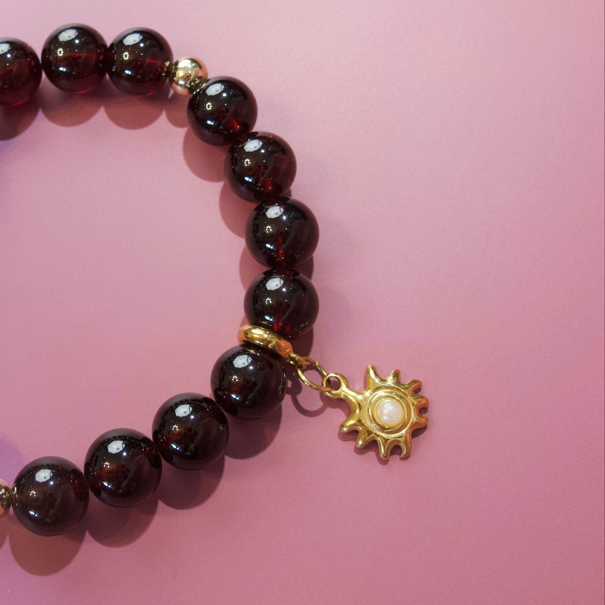 Close-up of red gemstone beads and gold-toned details