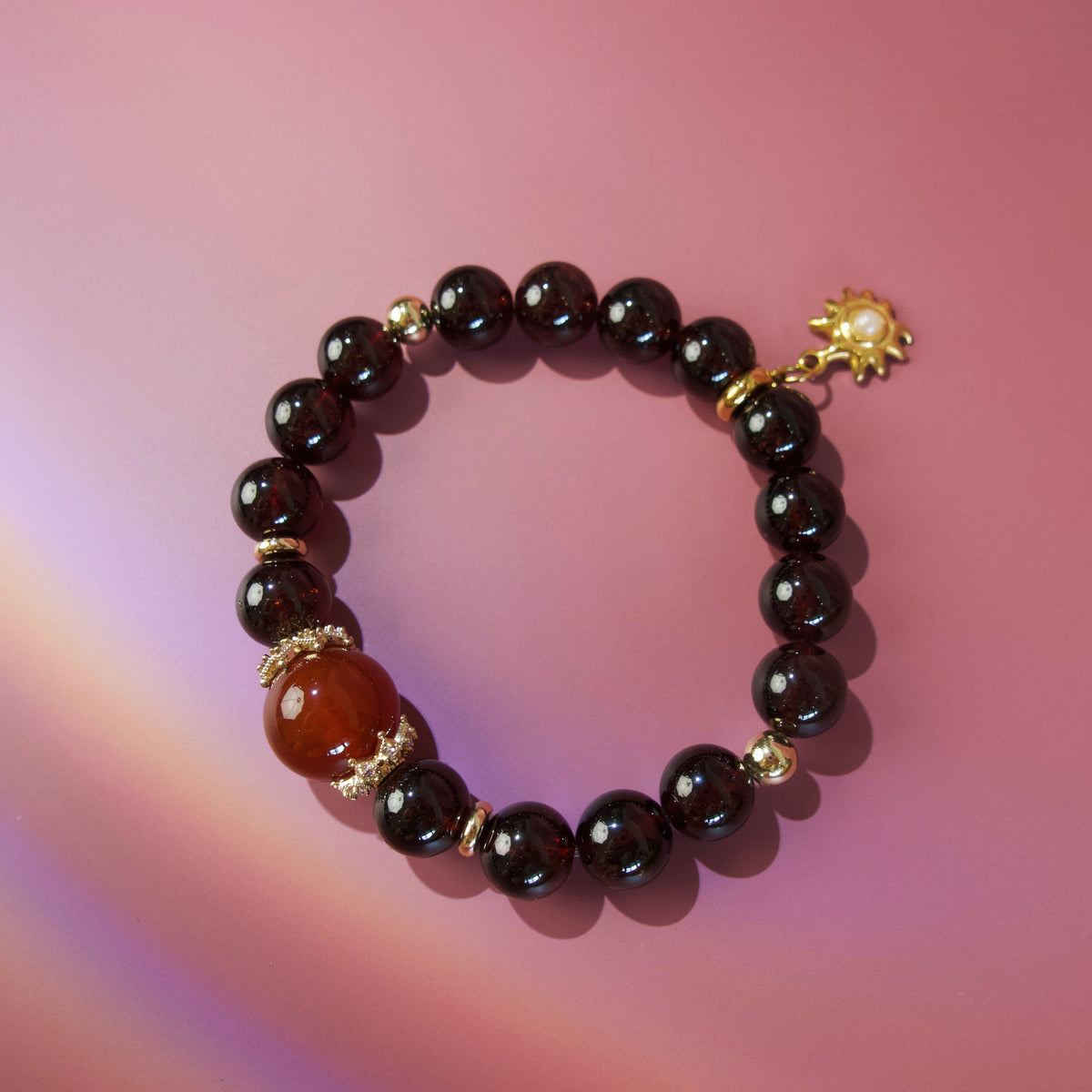 Red natural stone bracelet with deep garnet tones and gold details
