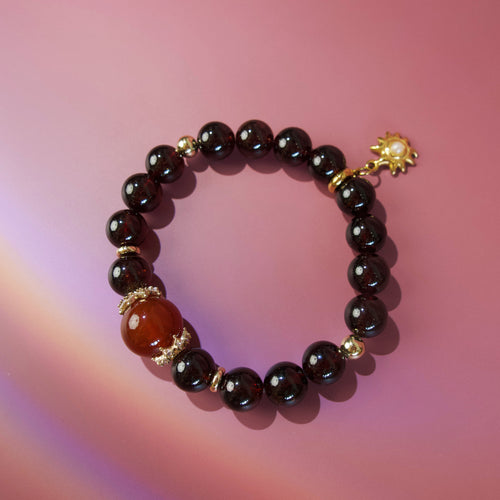 Red natural stone bracelet with deep garnet tones and gold details