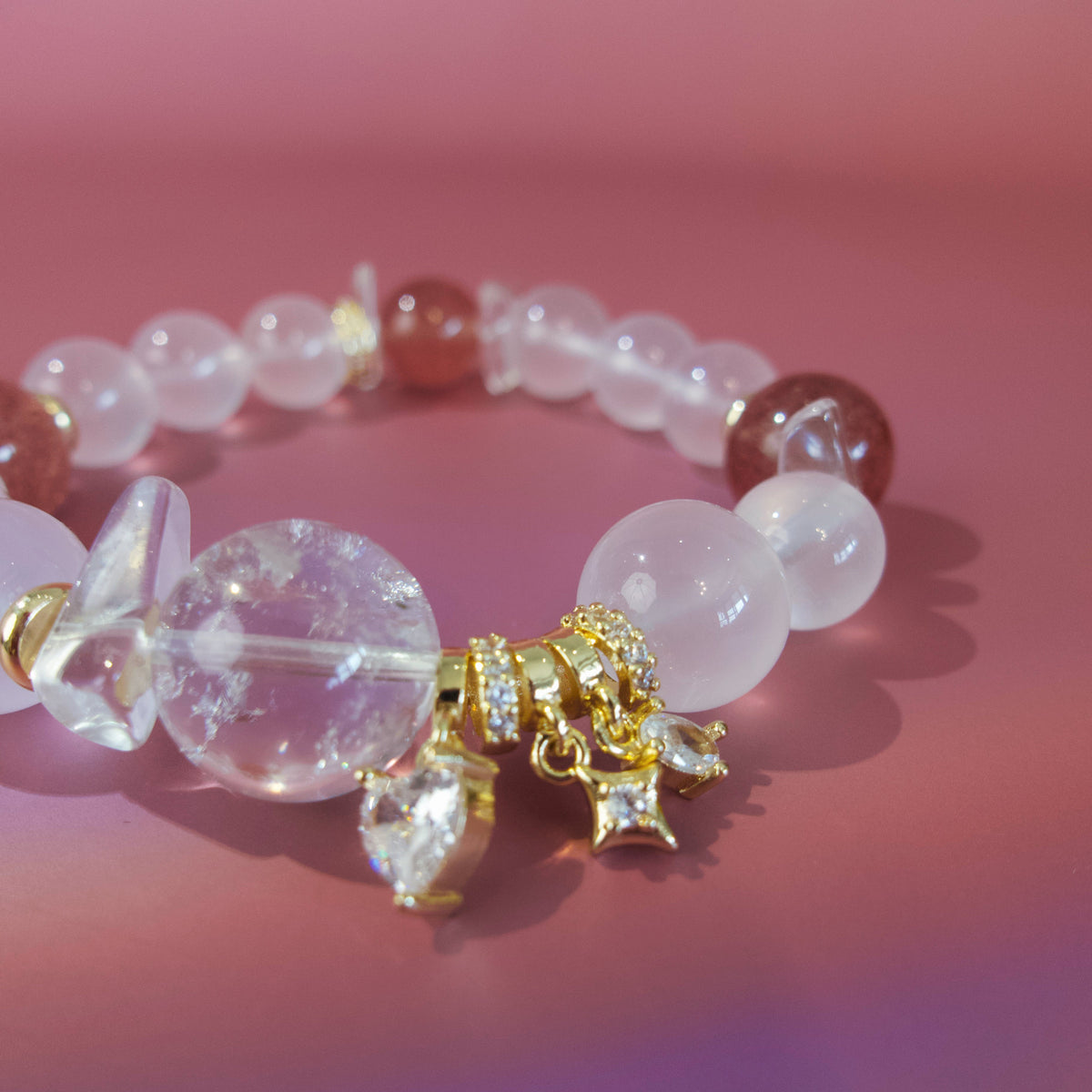 Close-up of pink crystal beads, clear stones and gold details