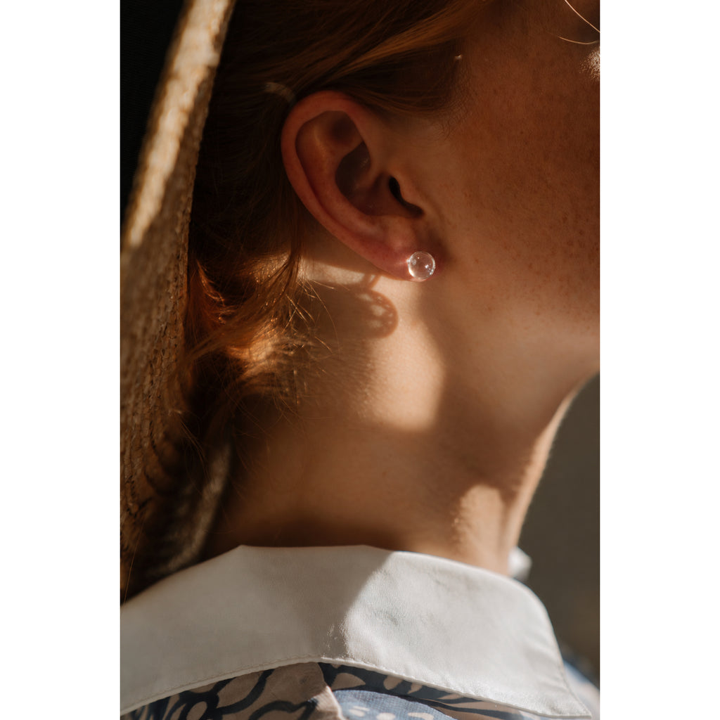 Clear quartz stud earrings worn on ear